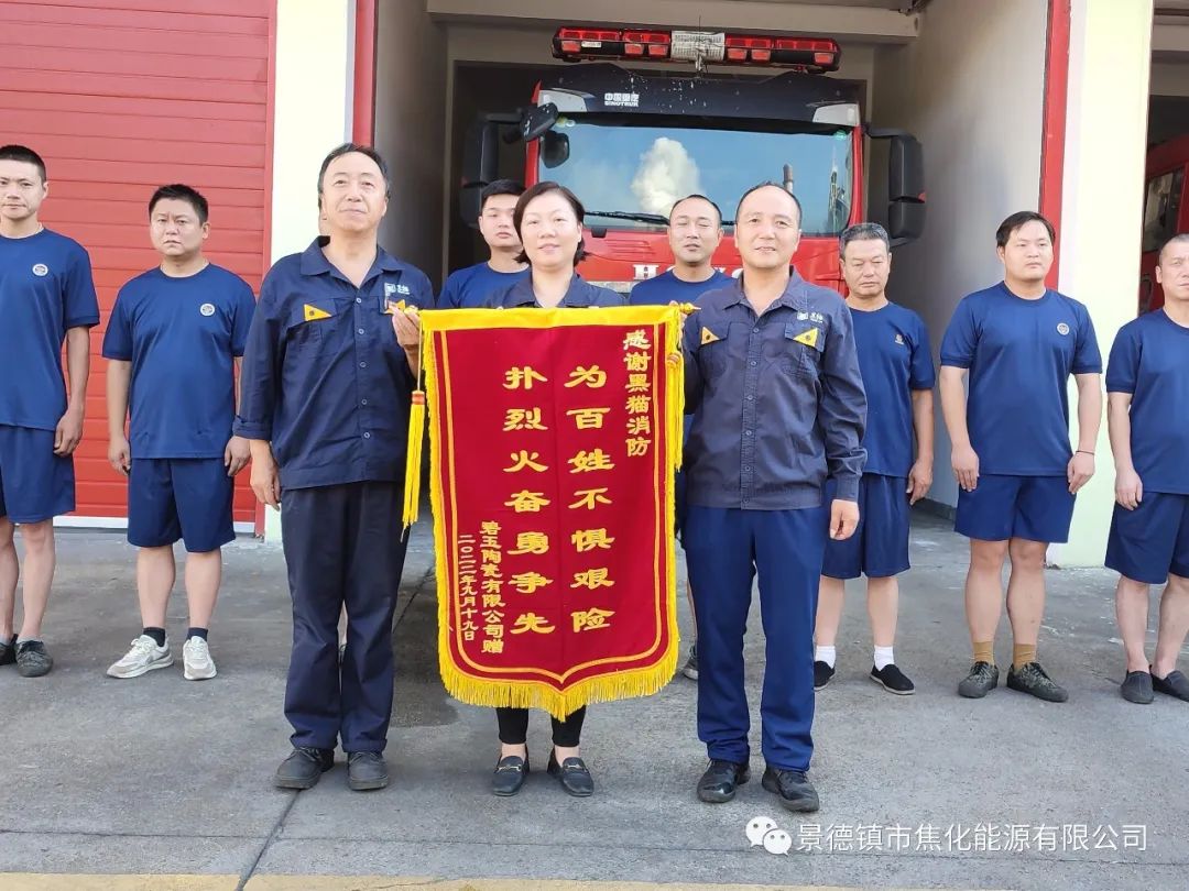 朱明紅、黑貓消防人員與錦旗合影.jpg